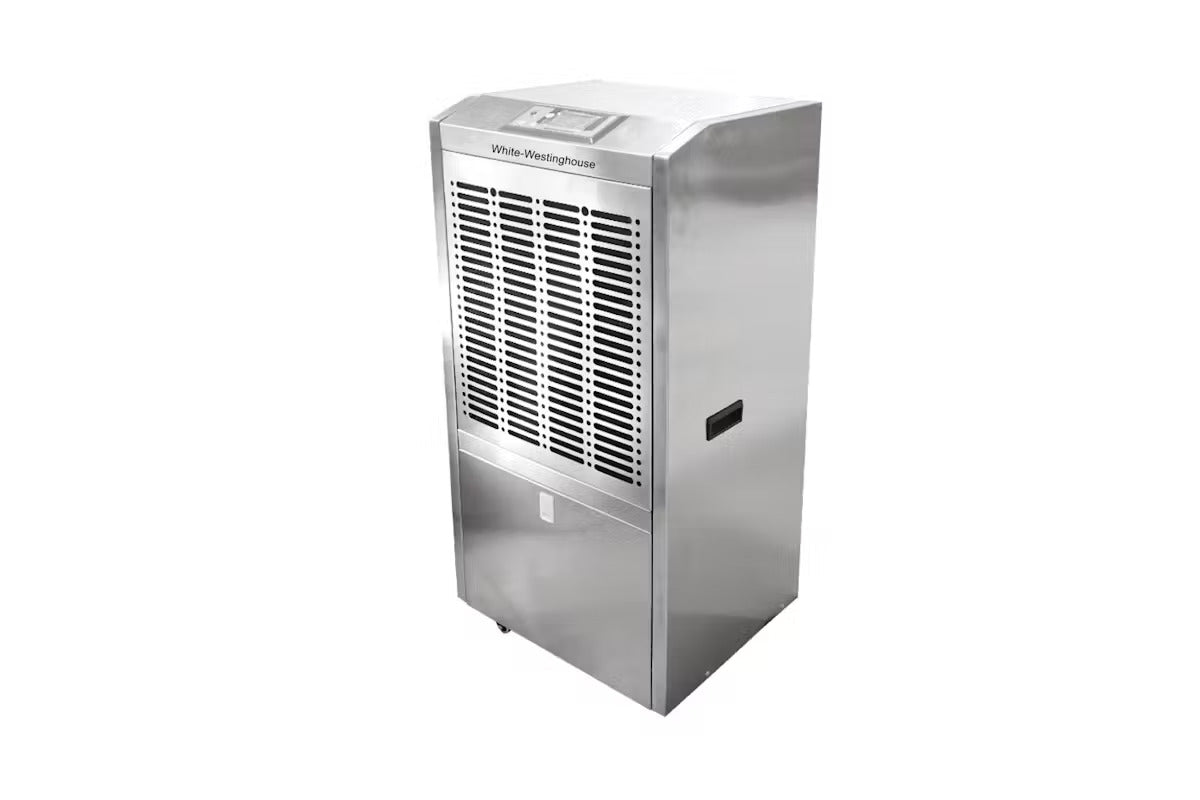 A White-Westinghouse commercial dehumidifier with a sleek metallic silver exterior. The unit features a grid of black ventilation slots on the top section and a solid panel on the bottom section. The branding "White-Westinghouse" is visible at the top. The dehumidifier has side handles and is mounted on small wheels for easy transport and mobility. It is designed for heavy-duty moisture control in large spaces.