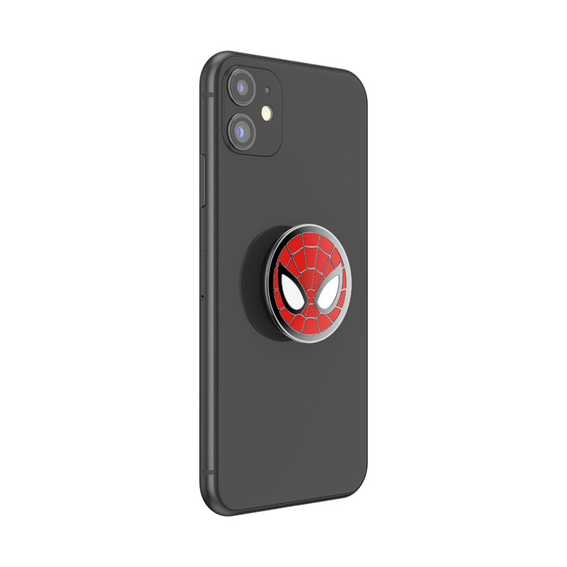A black smartphone with an attached Enamel Marvel Spider-Man PopGrip. The PopGrip features the iconic Spider-Man mask design with a red background, black web lines, and large white eyes outlined in black. The PopGrip is centrally positioned on the back of the phone, showing its circular shape and glossy finish. The phone's camera cutout is visible.