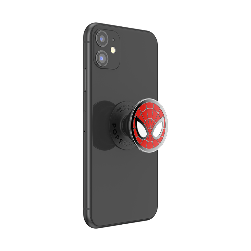 A black smartphone with an attached Enamel Marvel Spider-Man PopGrip in an extended position. The PopGrip features the iconic Spider-Man mask design with a red background, black web lines, and large white eyes outlined in black. The grip is centrally positioned on the back of the phone, showing its circular shape and glossy finish. The phone's camera cutout is visible.