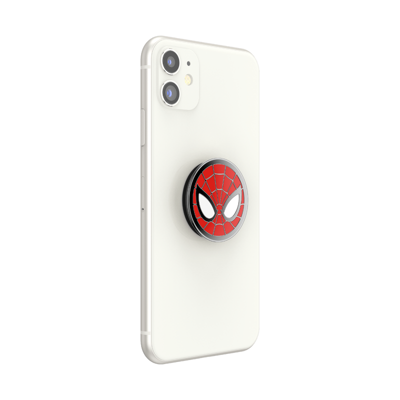 A white smartphone with an attached Enamel Marvel Spider-Man PopGrip. The PopGrip features the iconic Spider-Man mask design with a red background, black web lines, and large white eyes outlined in black. The PopGrip is centrally positioned on the back of the phone, showing its circular shape and glossy finish. The phone's camera cutout is visible.