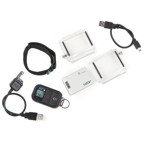 A collection of GoPro accessories is displayed. The items include two clear protective housing cases, a USB cable, a wrist strap, a remote control with a small display, and a keychain with a small rectangular device. The accessories are arranged neatly on a white background.