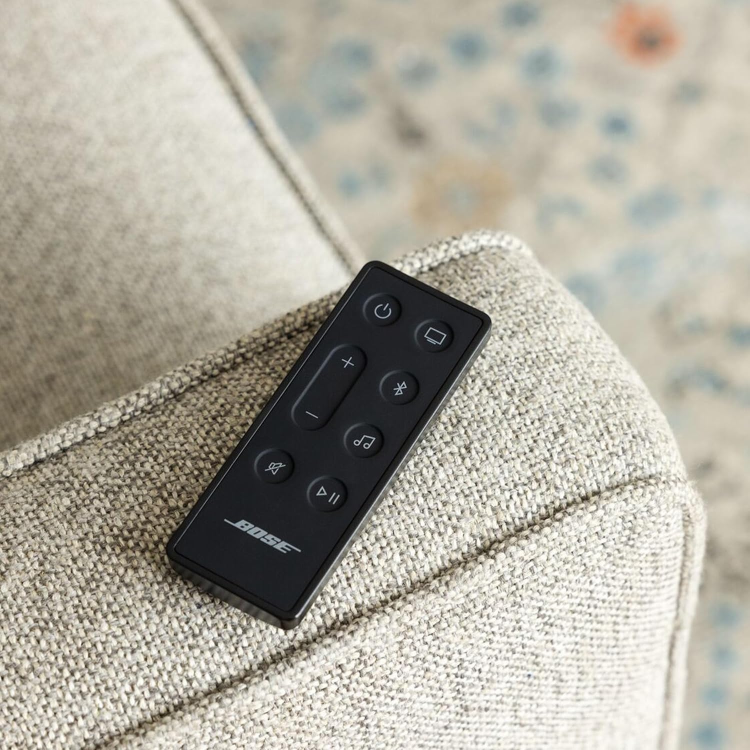 Bose remote control on a textured surface with a blurred background