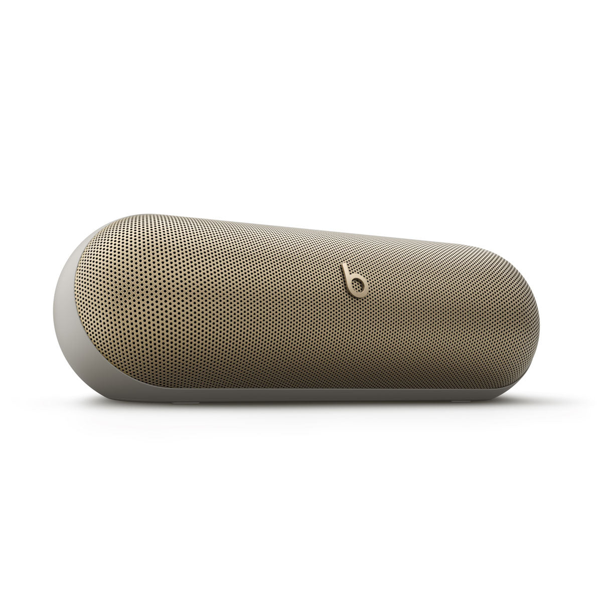 Alt text for this image:
Close-up view of a beige Beats portable speaker with a minimalist design, showcasing its smooth, rounded edges and perforated speaker grille for premium sound quality.