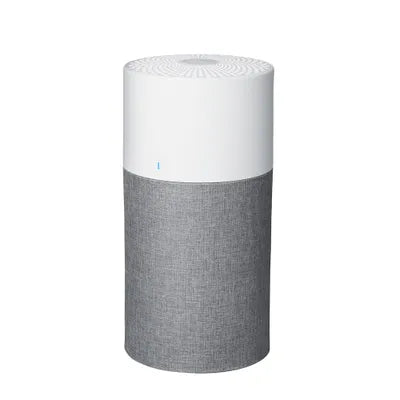 Modern cylindrical air purifier with a clean white top and grey fabric base, featuring a subtle blue LED indicator for intuitive operation.