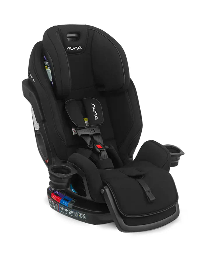 A black Nuna convertible car seat with a five-point harness, dual cup holders, padded leg rest, and color-coded base for installation guidance.