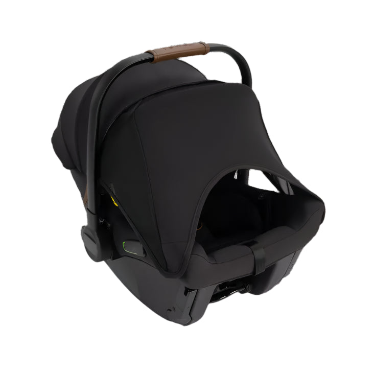 Rear three-quarter view of a black Nuna infant car seat with an extended canopy, ergonomic leatherette carry handle, and a peek-a-boo mesh window for ventilation.