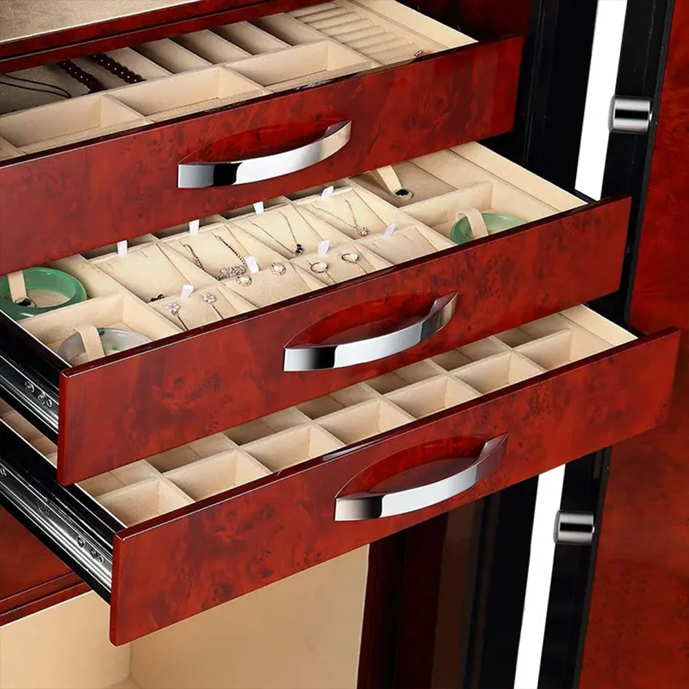 Close-up view of three open drawers inside a safe, each with a luxurious red wood-grain finish and sleek metallic handles. The drawers are lined with soft material and are designed for organized storage of jewelry and small items. The top drawer has compartments for rings and other small pieces, the middle drawer holds various jewelry items, and the bottom drawer has larger compartments for more significant items. The interior design emphasizes both elegance and functionality.