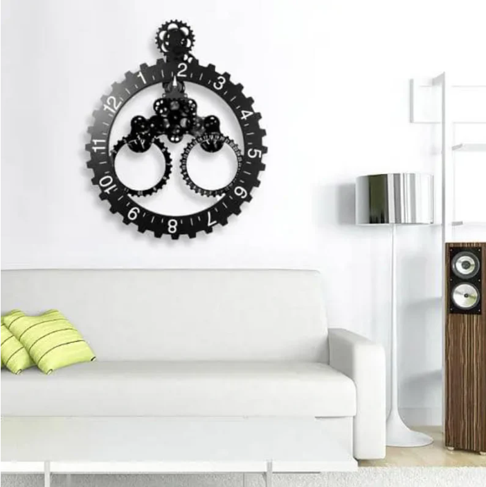 Modern living room with a striking black gear clock mounted on a white wall above a sleek white sofa adorned with a green-striped cushion. The setup includes a contemporary floor lamp and a wooden speaker unit, creating a stylish and minimalist decor.