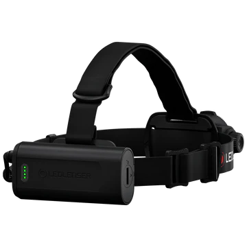 A black LED Lenser headlamp with an adjustable strap, shown from the side to highlight the attached battery pack. The battery pack features a green LED indicator showing the charge level. The LED Lenser logo is visible on the strap. The background is white, emphasizing the headlamp's design and components.