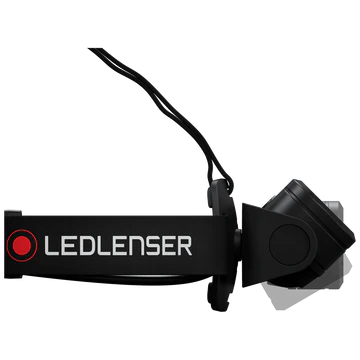 A side view of an LED Lenser headlamp, showing the adjustable black strap with the "LED LENSER" branding. The light unit is attached to the strap, with wires running from the light unit to the battery pack. The design highlights the secure attachment and adjustable features of the headlamp for comfortable wear.