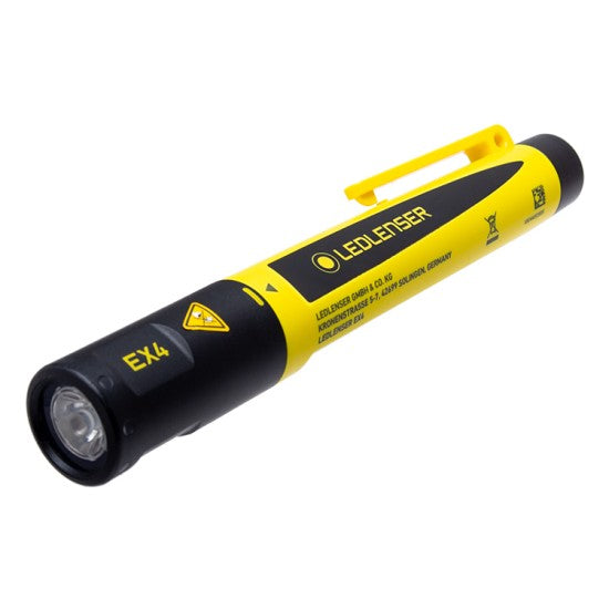 A yellow and black LED Lenser EX4 penlight lying on its side. The light features a pocket clip for easy attachment and has the branding "LED LENSER" along the side. The model name "EX4" is printed near the base along with other product details and safety symbols. The penlight has a cylindrical design with a lens at the front, indicating its functionality as a portable light source.