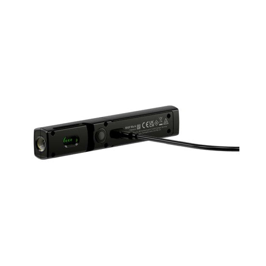 The back view of a sleek black LED penlight lying horizontally, with a USB cable connected to its charging port. The penlight features a rectangular design with certification markings and a green charging indicator. The penlight's round LED is visible on one end, and the clip is visible on the side for easy attachment.
