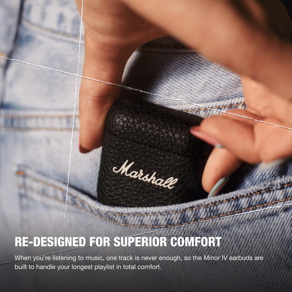 A close-up image of a hand placing a Marshall Minor IV earbuds case into the front pocket of a pair of jeans. The textured black case features the iconic Marshall logo, highlighting its compact and portable design. The promotional text emphasizes the earbuds' superior comfort and long-lasting performance, stating that they are designed to handle extended listening sessions with ease. The bold headline reads, "RE-DESIGNED FOR SUPERIOR COMFORT."