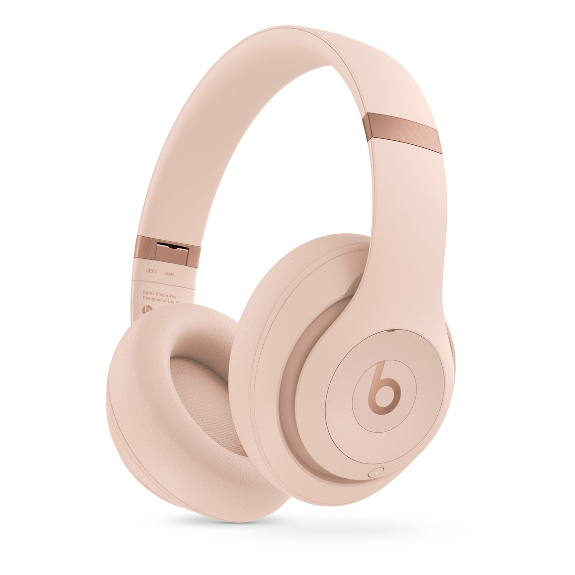 A soft pink over-ear headphone with plush ear cushions, featuring the "b" logo on the earcup and rose gold accents on the headband hinges, designed for a stylish and comfortable audio experience.