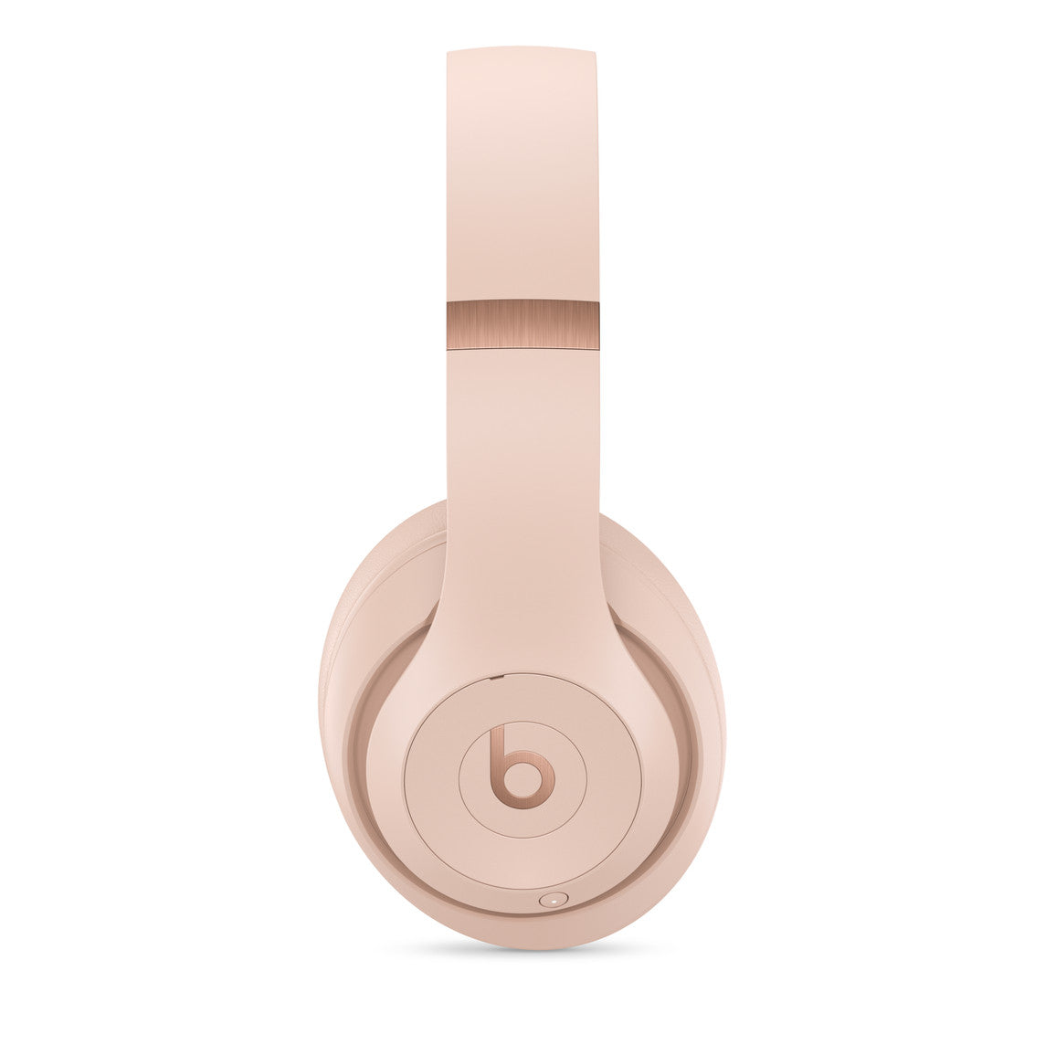 A side profile of soft pink over-ear headphones with a sleek design, featuring the iconic "b" logo on the earcup and rose gold detailing on the headband hinge.