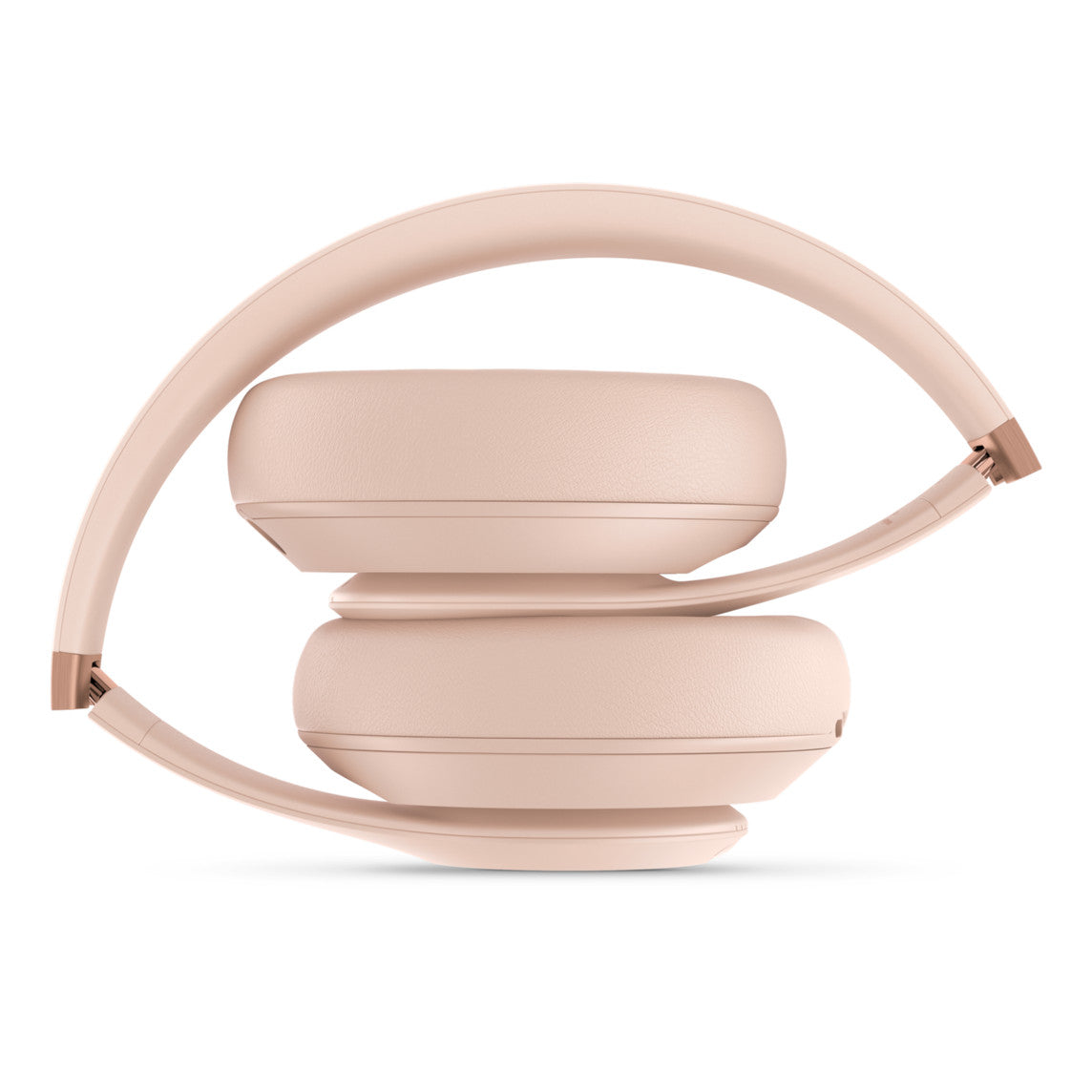 A pair of soft pink over-ear headphones folded neatly, showcasing their compact and portable design, with rose gold accents visible on the hinges.