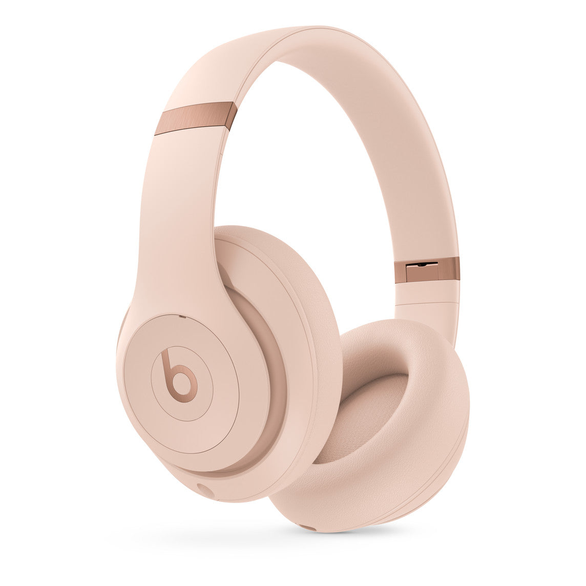A pair of over-ear headphones in a soft pink color, featuring the iconic "b" logo on the earcups and sleek rose gold accents on the headband for a modern and stylish design.