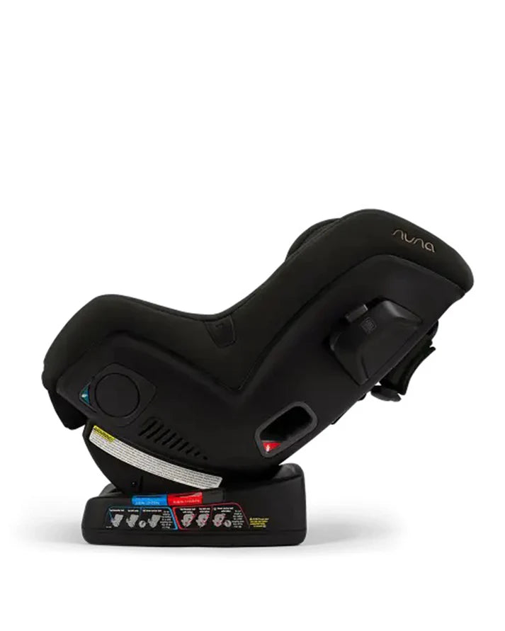 Side view of a Nuna black convertible car seat in a rear-facing reclined position, showing safety labels, ventilation slots, and ISOFIX-compatible base for secure installation.