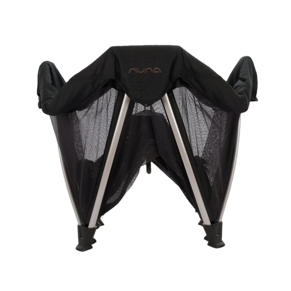 This is a folded Nuna travel crib or bassinet with mesh sides and angled metal legs, designed for compact storage and portability.
