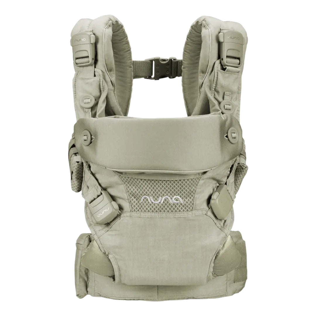 This image shows a Nuna baby carrier in a soft beige tone, featuring adjustable padded shoulder straps, breathable mesh paneling, and secure fasteners for comfortable and ergonomic babywearing.