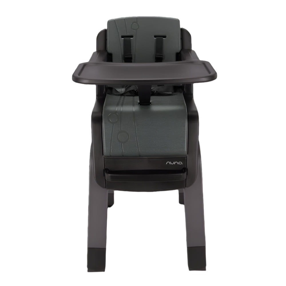 Front view of a Nuna high chair in dark green and black featuring a five-point harness, footrest, and removable tray, designed for secure and adjustable toddler seating.