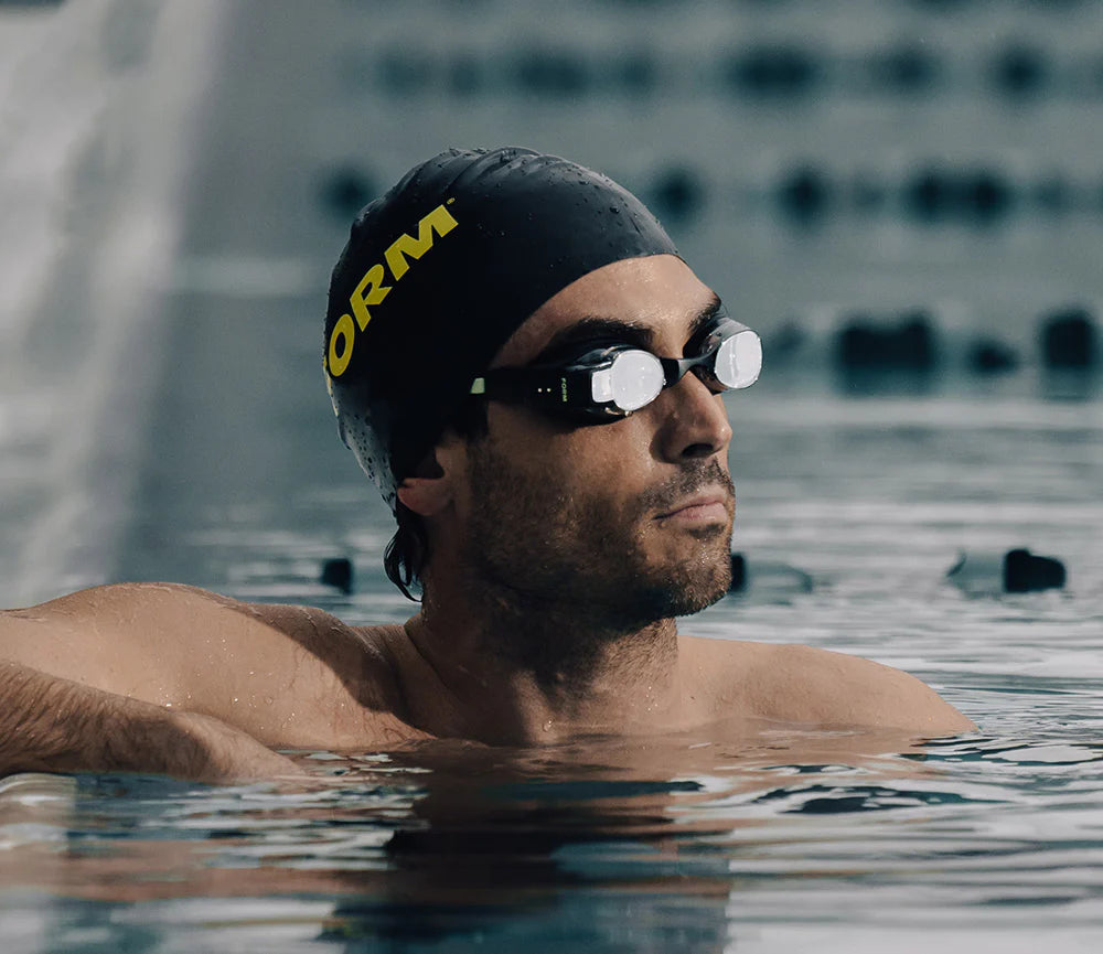 This image showcases a swimmer wearing FORM Smart Swim Goggles, designed to display real-time metrics such as distance, time, and pace directly in the swimmer's field of vision while training or racing in the pool.