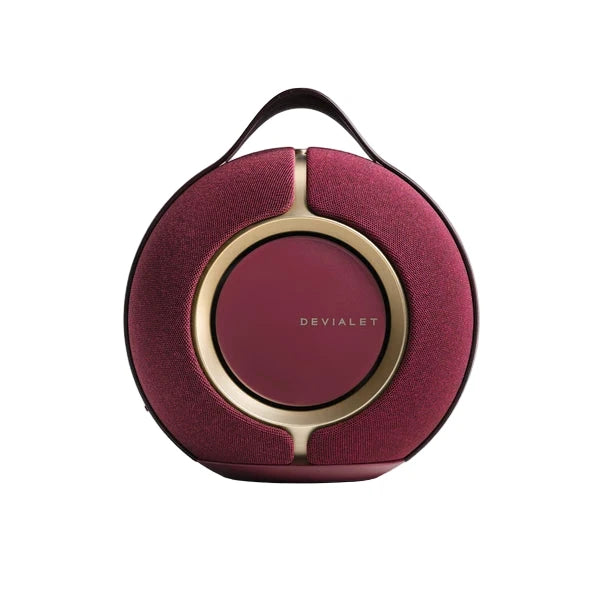 Round red carrying case with gold accents and 'Devialet' branding on a white background
