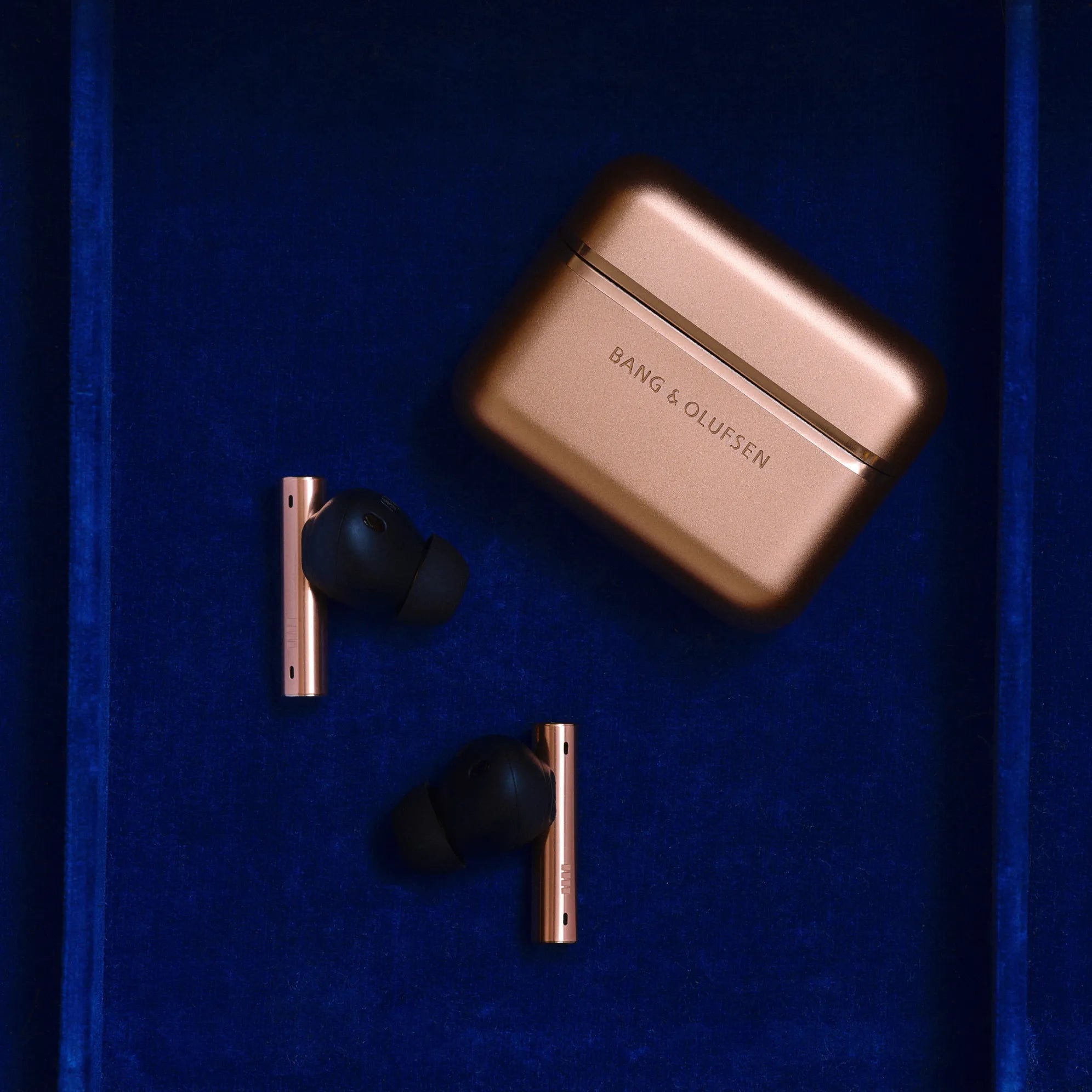 Honey Tone earbuds held in hand, showing warm metallic finish