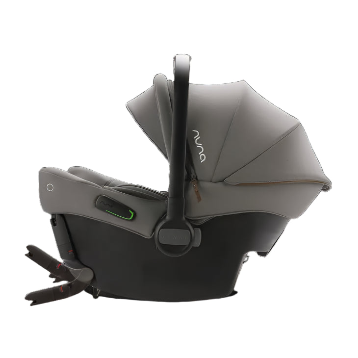 A side view of a Nuna infant car seat in grey with a fully extended canopy, upright carry handle, and visible green safety indicator and ISOFIX connectors extended for vehicle installation.