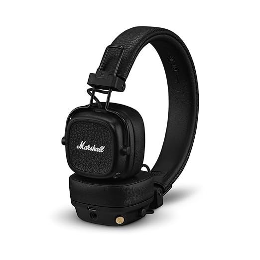 Marshall over-ear headphones with a signature black design, featuring a textured ear cup surface and the iconic Marshall logo in white. The headphones have an adjustable headband with a leather-like texture for comfort and durability. The ear cups are cushioned for long listening sessions, and the design includes a multi-directional control knob for easy navigation, along with gold accent details for a premium look. These headphones offer both wireless and wired connectivity options, providing flexibility f