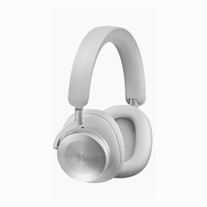 This image shows a **Bang & Olufsen over-ear headphone** in a **light gray** or **silver color**. The ear cups are made of **soft memory foam** encased in light gray, with the outer shell crafted from **brushed aluminum** that displays the **B&O logo**. The headband, wrapped in **premium leather**, also matches the light gray tone, contributing to the minimalist, sleek, and luxurious design. These headphones are part of **Bang & Olufsen's premium product line**, known for their elegant aesthetics and superi
