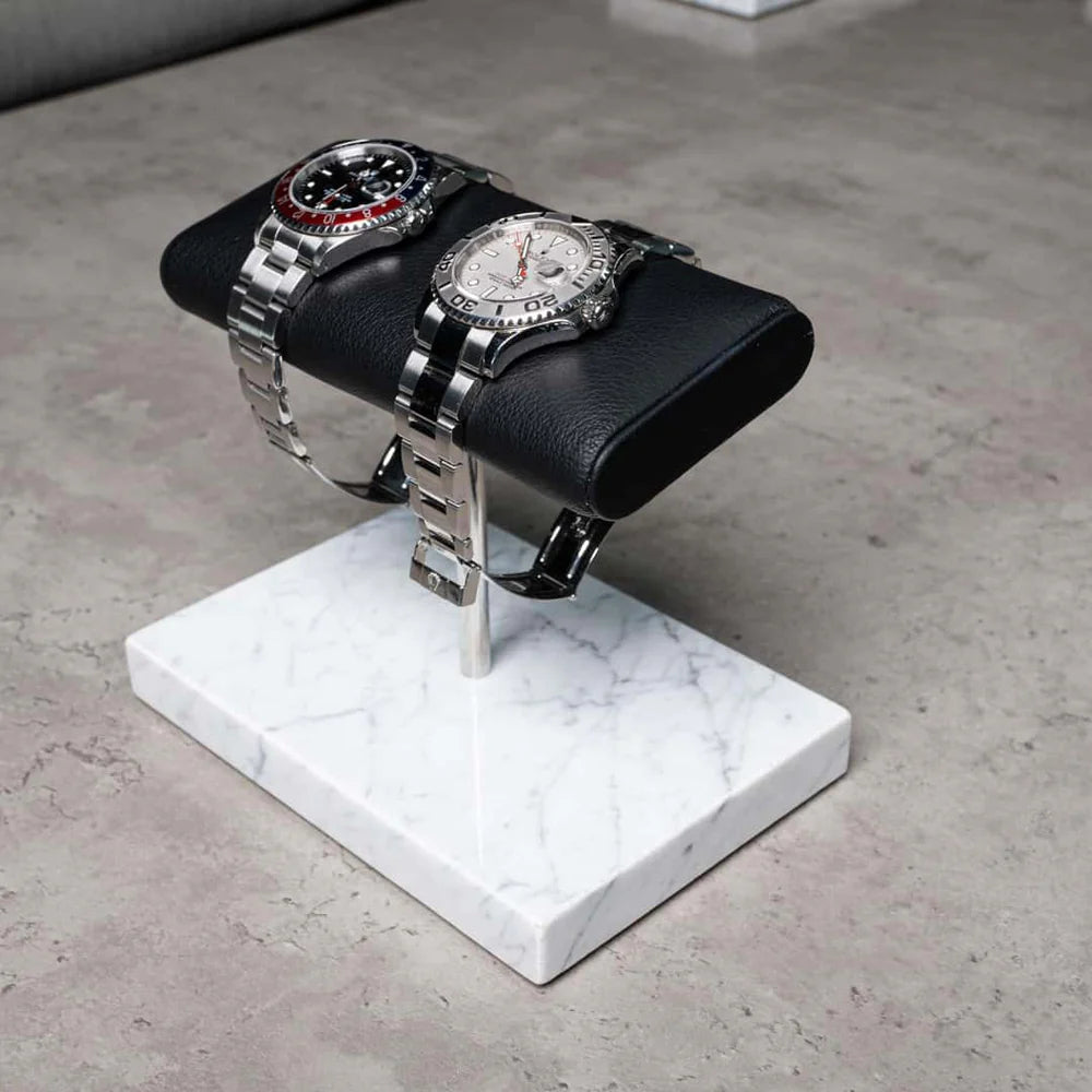 Double luxury watch stand with a black leather cushion and a white marble base, designed for displaying premium timepieces.