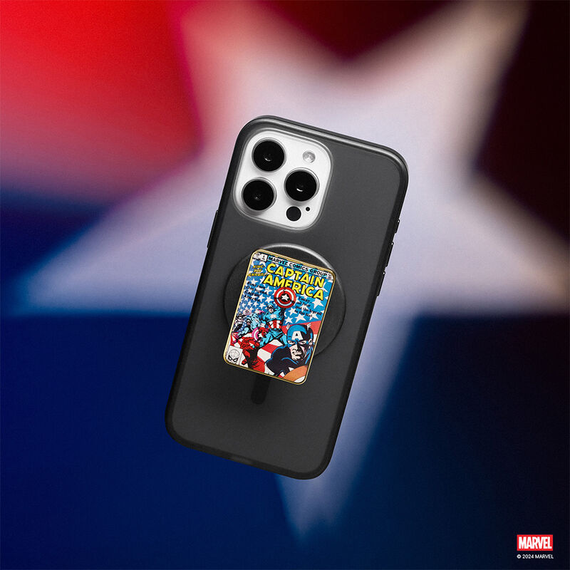  Black smartphone case with a Popsocket Enamel Captain America Comic Book PopGrip for MagSafe attached. The PopGrip features a colorful comic book cover design with Captain America. The background includes a blurred star, adding a patriotic theme to the image