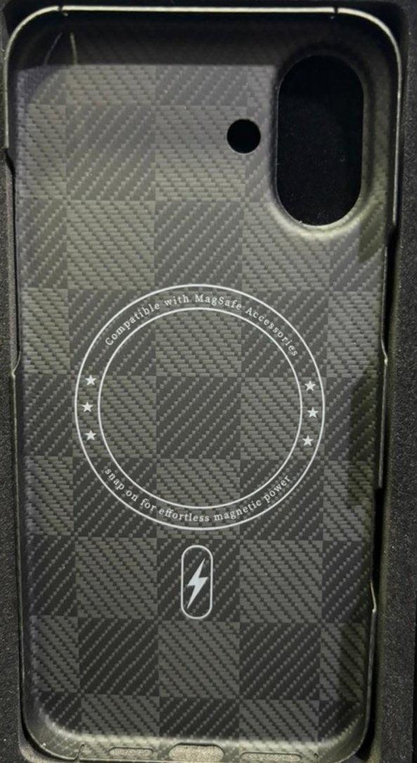 This is an image of a smartphone case with a textured checkerboard pattern similar to carbon fiber. The case has a cutout for a single rear camera and appears to be compatible with MagSafe accessories, as indicated by the circular marking inside with text stating "Compatible with MagSafe Accessories." The interior design also highlights a designated magnetic charging spot, symbolized by a lightning icon at the bottom, ensuring alignment for wireless charging. The case combines style with functionality, tail