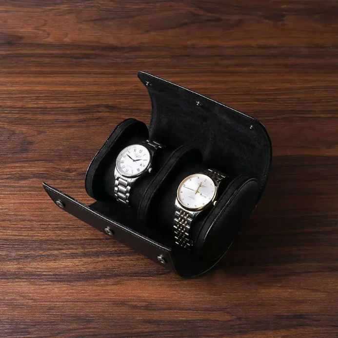 Black leather watch roll case with two elegant silver wristwatches, perfect for travel and secure storage.