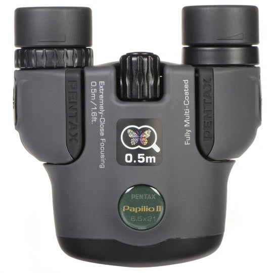 Here's the alt text for this image:  "Front view of Pentax 8.5x21 U-Series Papilio II binoculars, showcasing the extremely close focusing capability of 0.5m and fully multi-coated optics, perfect for detailed and close-up observations."  This alt text includes relevant keywords and provides a clear description of the product's features for SEO purposes on your Shopify website.