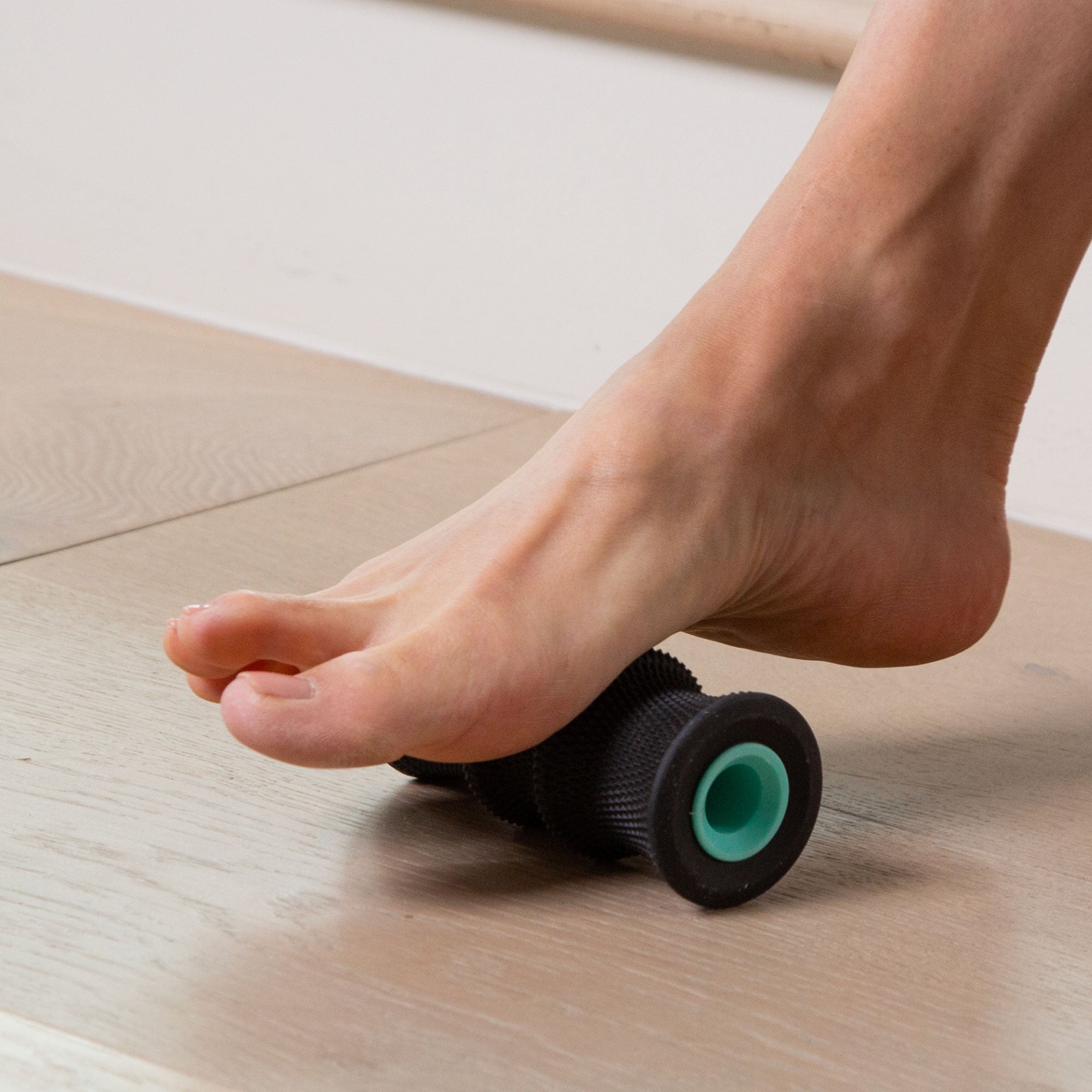 Person rolling the arch of their foot on the Chirp 2 inch Foot Roller