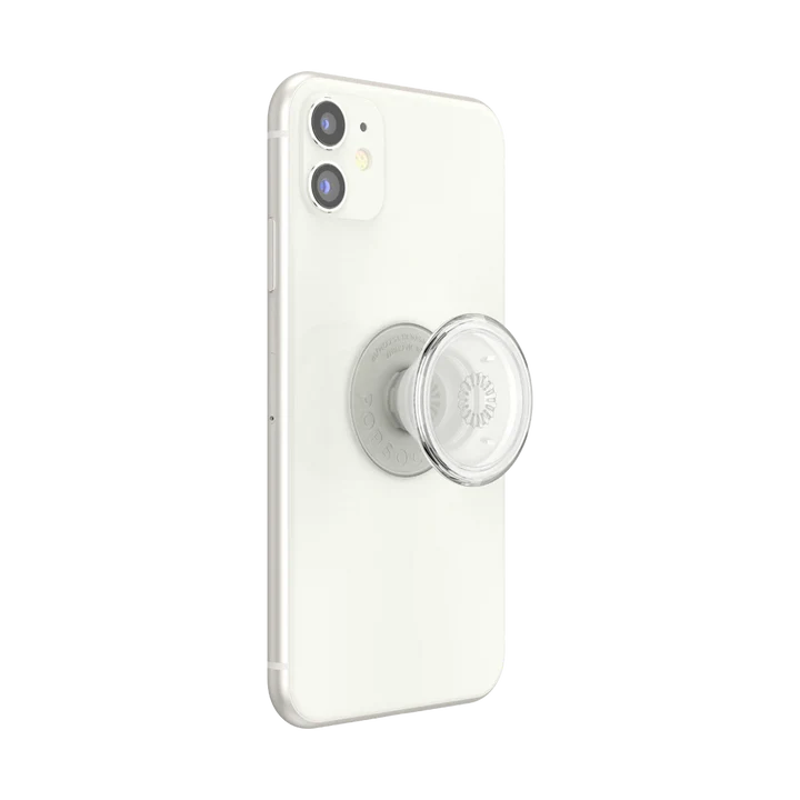 A white smartphone with a clear PopSockets PopGrip attached to the back, shown in its extended state. The grip features a transparent, circular top with a central radial pattern, allowing the phone's design to remain visible. The clear PopGrip provides a functional and stylish accessory for holding and supporting the smartphone.