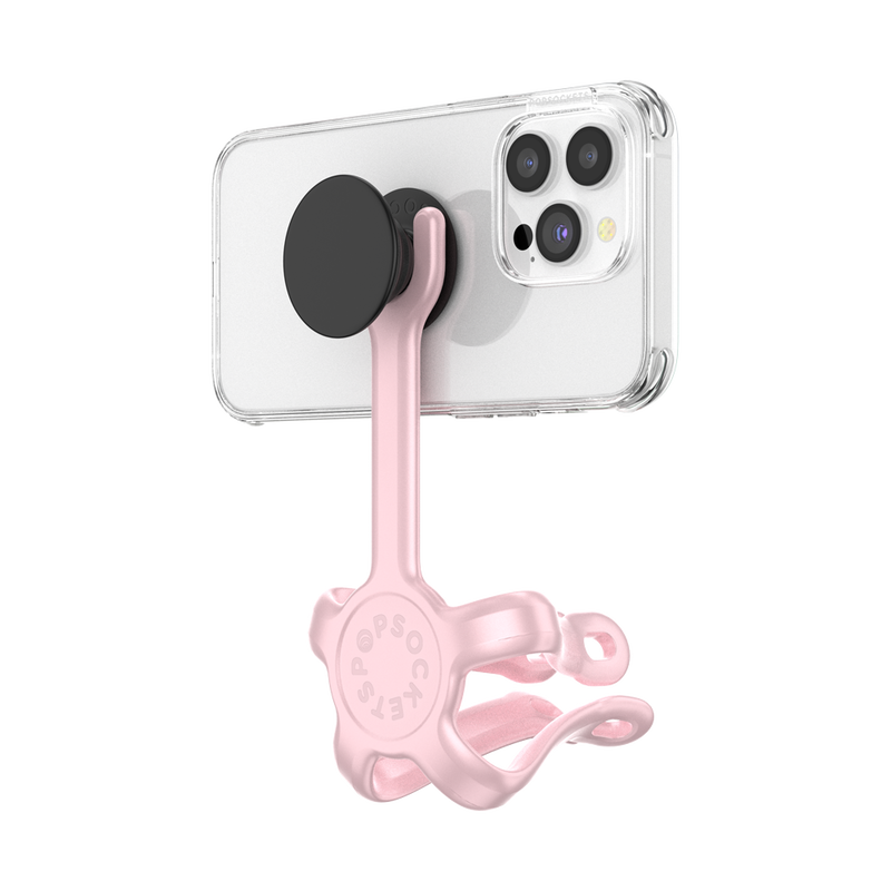  PopSockets Flex Mount in Pinky color holding a smartphone in a clear case with a black PopGrip attached to the back. The mount's flexible legs are wrapped around themselves to create a stable base, securing the smartphone in a horizontal position. The phone is shown from the back at a slight angle, highlighting the PopGrip and the light pink colored flexible mount's secure attachment.