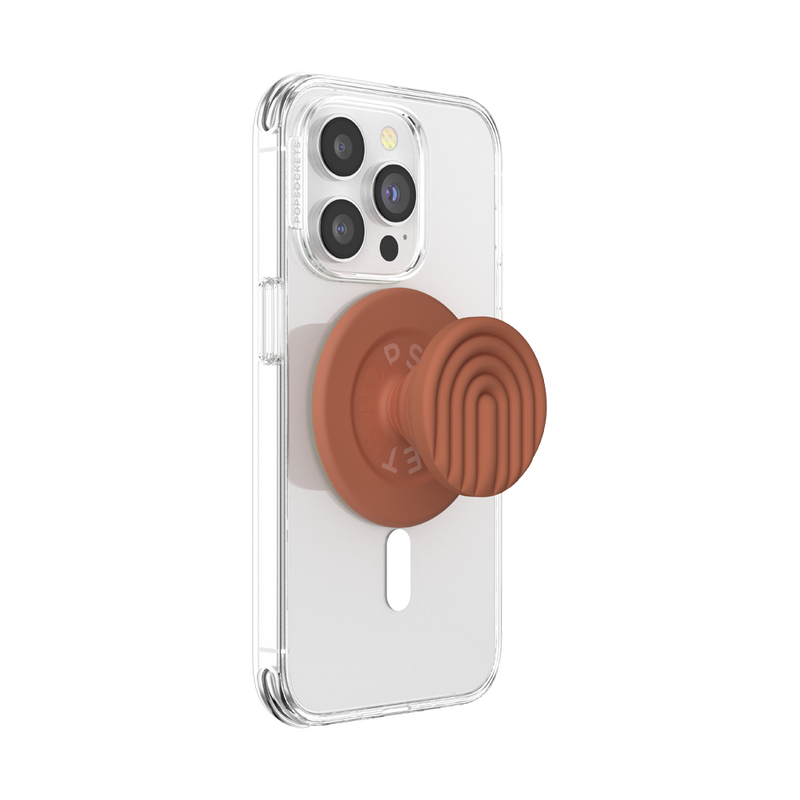 A clear phone case is shown attached to a smartphone with a PopOut Terracotta Curves PopGrip for MagSafe. The PopGrip, featuring a terracotta-colored design with curved lines, is fully extended, providing a secure and stylish hold for the device