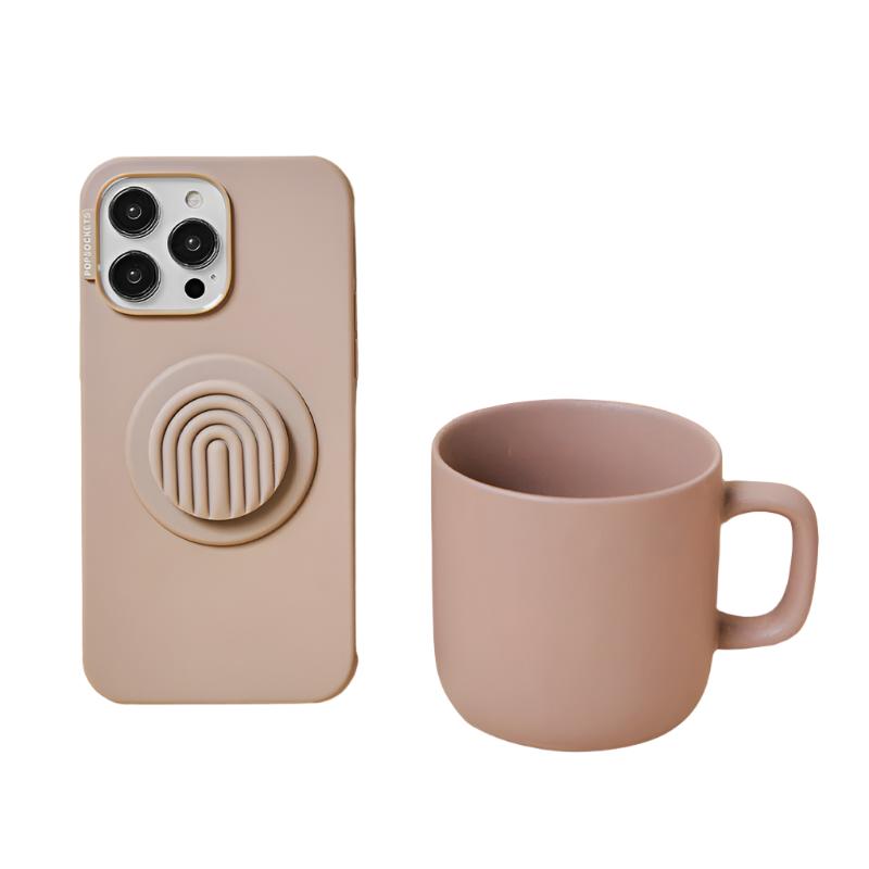 A beige phone case with a PopOut Latte Curves PopGrip attached is displayed next to a matching beige mug. The PopGrip features a latte-colored design with curved lines, complementing the minimalist and stylish aesthetic of both the phone case and the mug