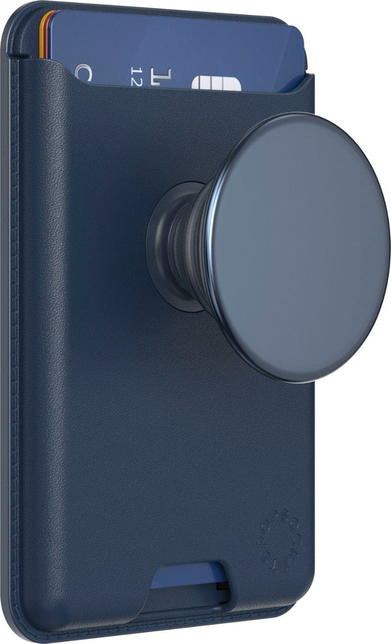  A navy blue leather PopSockets MagSafe Softgoods PopWallet attached to a phone. The wallet features a circular PopSocket on the back and a blue card partially inserted into the card slot. The image highlights the wallet's sleek design and practical functionality, with visible texture and subtle branding.