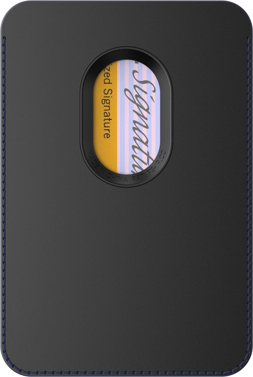 A close-up view of the back side of a black leather PopSockets MagSafe Softgoods PopWallet. The wallet features a small oval window displaying part of a card with the word "Signature" visible. The edges of the wallet have a visible blue stitching.