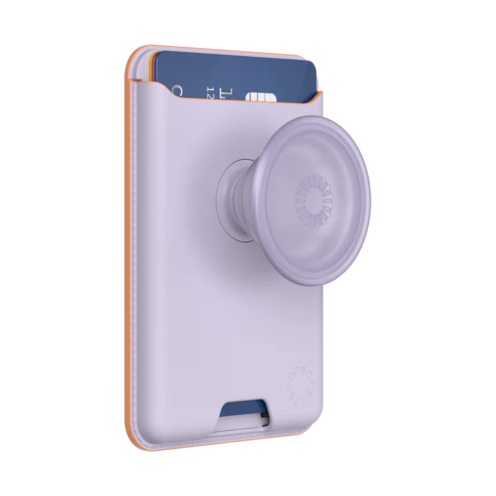 PopSockets MagSafe Softgoods PopWallet in Pale Lavender color. The wallet is shown with a credit card partially inserted in the top slot. The attached PopSocket in matching pale lavender color is prominently displayed, providing grip and functionality. The PopWallet features neat stitching along the edges and the "PopSockets" logo embossed near the bottom corner. The wallet's soft material and sleek design are highlighted.