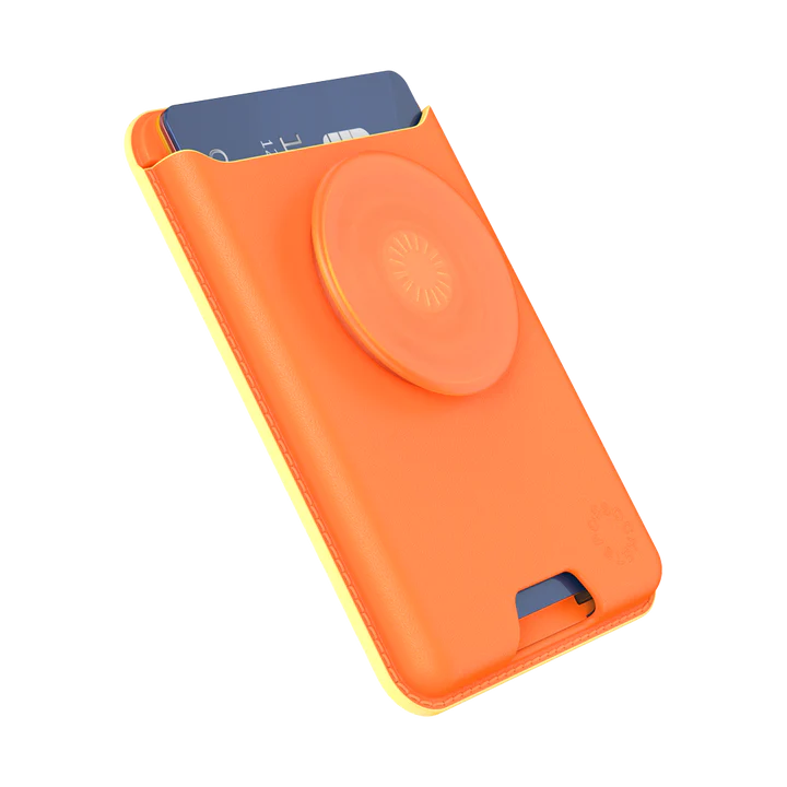 A Softgoods PopWallet for MagSafe in a bright cantaloupe color, holding a blue card in its pocket, shown from an angled perspective. The wallet features a circular PopGrip in the same cantaloupe color on its front, designed for a secure grip and added functionality. The edges of the wallet have a yellow accent, enhancing its vibrant look. The design is sleek and practical, with a slot for easy card access.