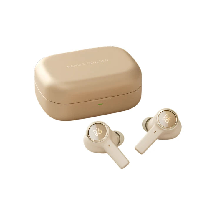 The image depicts beige Bang & Olufsen wireless earbuds alongside their charging case. The earbuds feature the iconic "B&O" logo on each piece, and the charging case has a smooth, elegant finish with the Bang & Olufsen branding on top. The design reflects a minimalist and luxurious aesthetic typical of the brand.