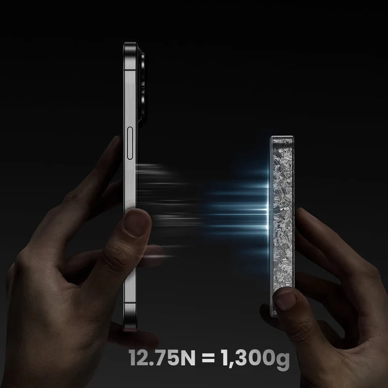 A pair of hands holding a smartphone on the left and a textured gray MagSafe-compatible accessory on the right. Blue light beams depict the strong magnetic attraction between the two. Below, the text "12.75N = 1,300g" highlights the magnetic holding force. The dark background emphasizes the product's durability and functionality.