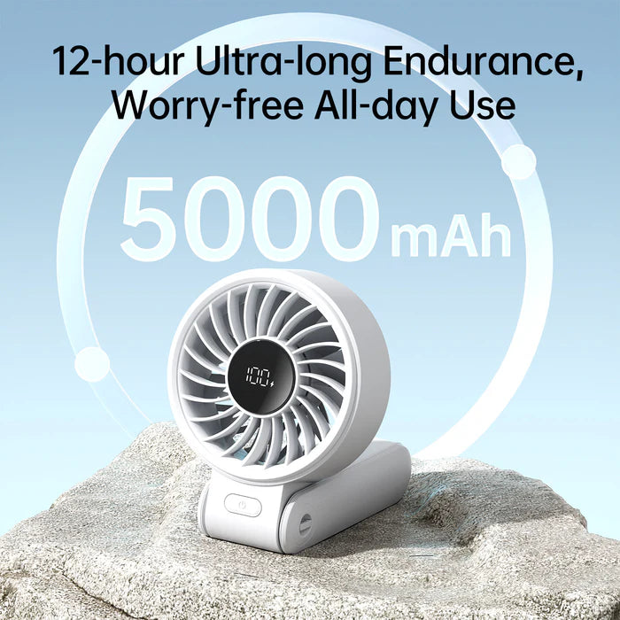 The image showcases a white portable Jisulife fan with a digital display in the center of the fan grill, indicating "100%". The fan is set on a rock with the text "12-hour Ultra-long Endurance, Worry-free All-day Use" prominently displayed above it, along with "5000 mAh" in large font, emphasizing the battery capacity. The design suggests a durable and reliable fan for long-term use.