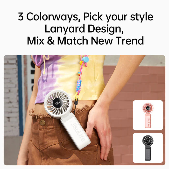 The image displays a person wearing a lanyard with a Jisulife portable fan attached to their waist, highlighting the fan's portability and stylish design. The text at the top reads, "3 Colorways, Pick your style, Lanyard Design, Mix & Match New Trend," emphasizing the fan's versatility and fashion-forward appeal. The image also features two smaller images of the fan in different colors—pink and black—showcasing the available color options. The overall design promotes the fan as a trendy and functional acces