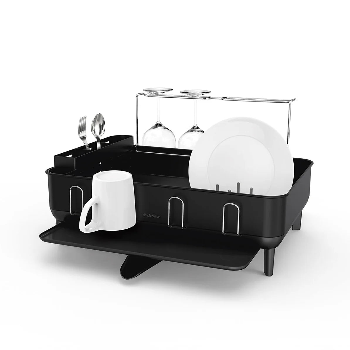 The image features a modern black dish drying rack designed with a compact and efficient layout. The rack holds several items, including plates, a mug, and wine glasses, showcasing its capacity to organize various kitchenware. It has designated slots for plates and a separate section for utensils, along with a wine glass holder. The rack is elevated on small legs, providing stability, and includes a draining spout underneath to ensure water flows out efficiently, keeping your countertop dry. The design is b